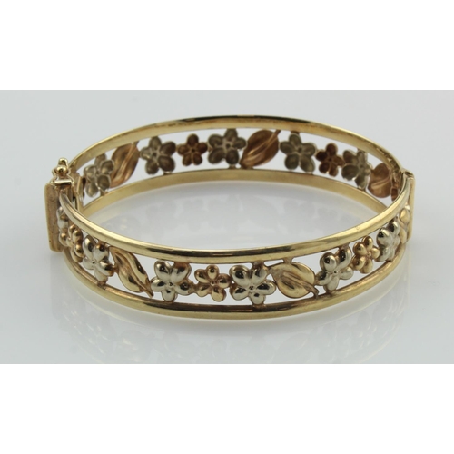 359 - 9ct yellow gold filigree bangle, highlighted with white gold flower details, 14mm wide, hinged with ... 