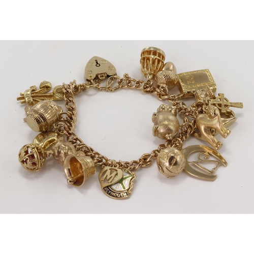 472 - 9ct / yellow metal charm bracelet with a good assortment of charms attached. Total weight 46.6g