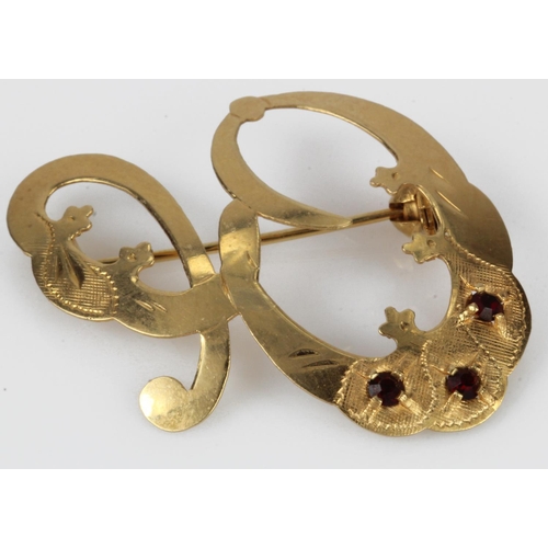 502 - Yellow gold (tests 18ct) 'E' initial brooch, set with red paste stones, length 30mm, weight 2.5g.