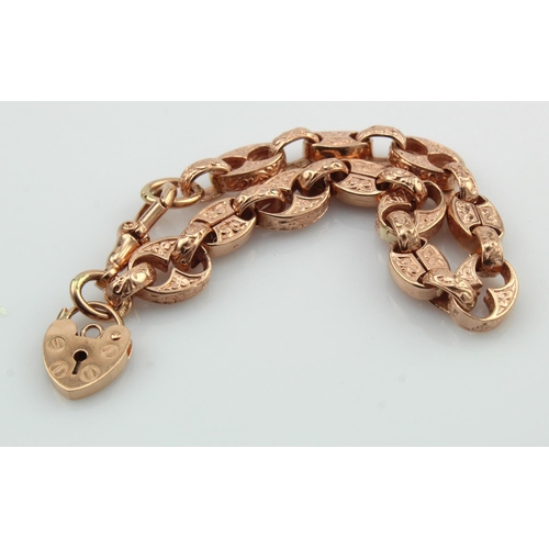 555 - Rose gold (tests 9ct) fancy textured linked bracelet, dog clip clasp with heart padlock charm attach... 