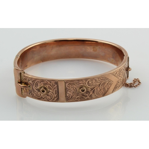 584 - 9ct rose gold vintage buckle bangle, top engraved with scroll and foliate details, hinged with box c... 