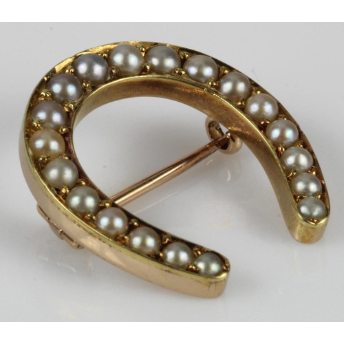 613 - Yellow gold (tests 9ct) vintage horse shoe brooch set with graduating half pearls, length approx. 25... 