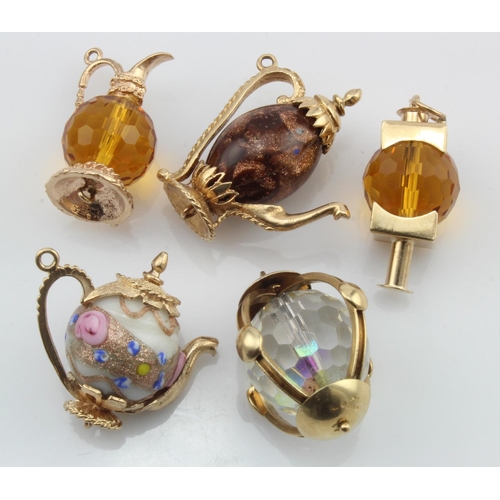 634 - Five 9ct gold charms, lanterns and teapots, set with glass, total weight 42.6g.