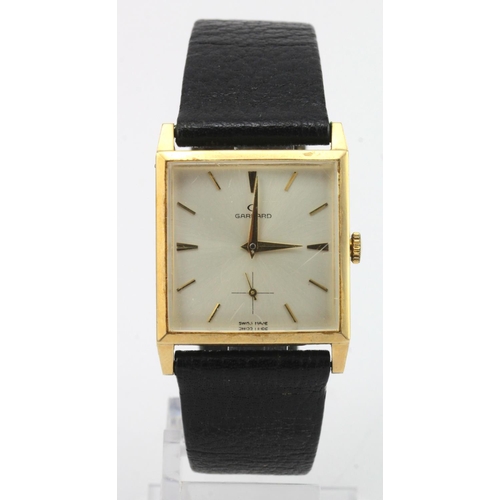 678 - Gents 9ct cased Garrards manual wind wristwatch. The square silver dial with gilt baton markers and ... 