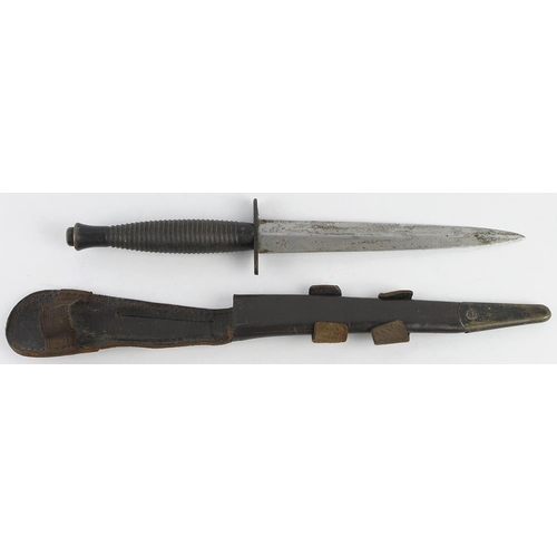 952 - Commando dagger housed in its leather and metal tipped scabbard. Marked 'William Rodgers Sheffield E... 