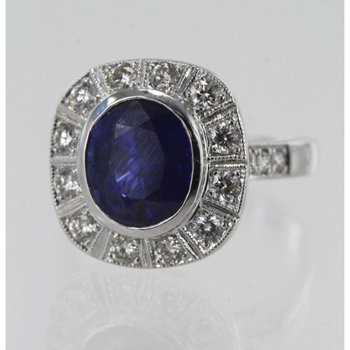 107 - White gold (tests 18ct) diamond and sapphire cluster ring, oval sapphire measures approx.10mm x 8mm,... 