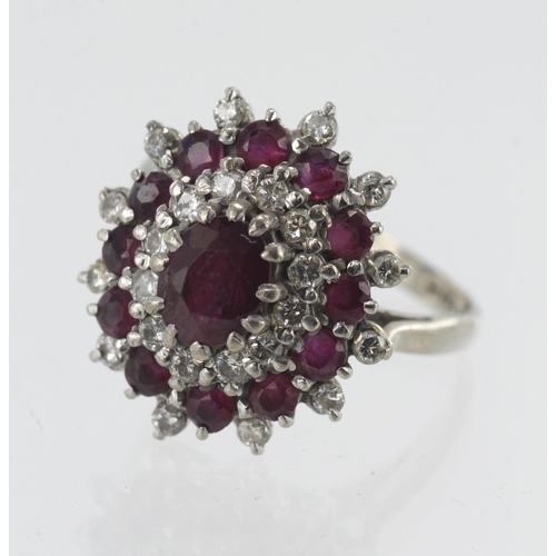 144 - 18ct white gold diamond and ruby triple cluster ring, principle ruby measures 7mm x 5mm, single halo... 