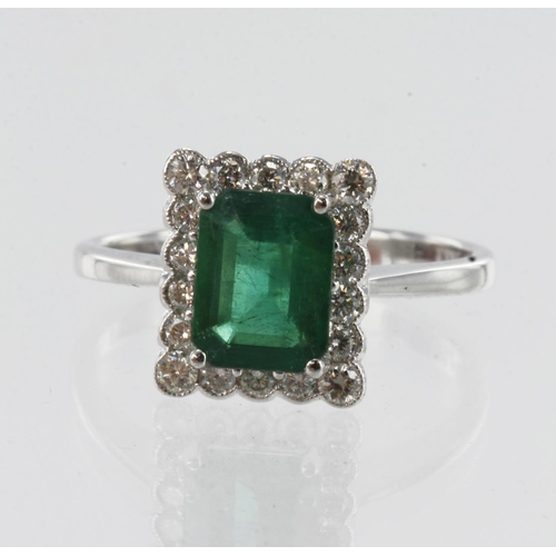 184 - White gold (tests 18ct) diamond and emerald cluster ring, emerald-cut emerald measures 7.8mm x 6mm, ... 