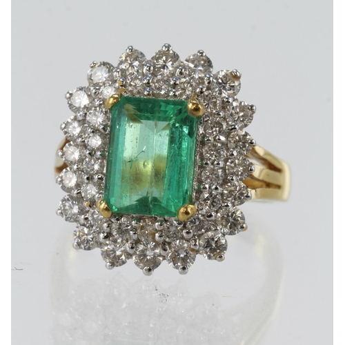 217 - Yellow gold (tests 18ct) diamond and emerald double halo cluster ring, step cut emerald approx. 2.43... 