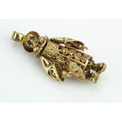 615 - 9ct yellow gold articulated oriental man charm, set with blue stone eyes, length 45mm, weight 12.5g.