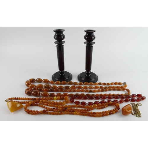 635 - Assortment of amber, platic and glass bead necklaces, one brooch, also with a pair of bakelite candl... 