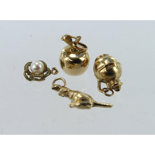 638 - Four 9ct gold/tests 9ct charms, one set with a cultured pearl, total weight 4.3g.