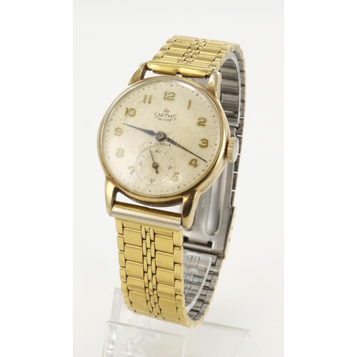 21 - Gents 9ct cased Smiths De Luxe manual wind wristwatch, hallmarked Birmingham 1957. The cream dial wi... 