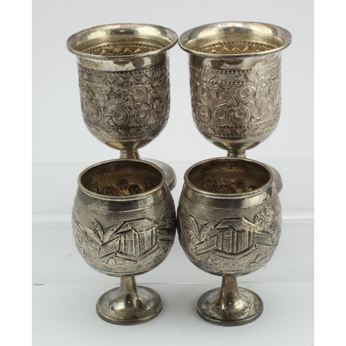 532 - Four white metal cups (tests as silver), each with ornate decoration, tallest 11cm approx., weight 1... 