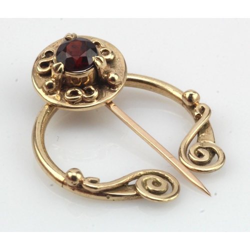 544 - 9ct yellow gold Celtic penannular brooch, set with one 5mm garnet, weight 5.3g.