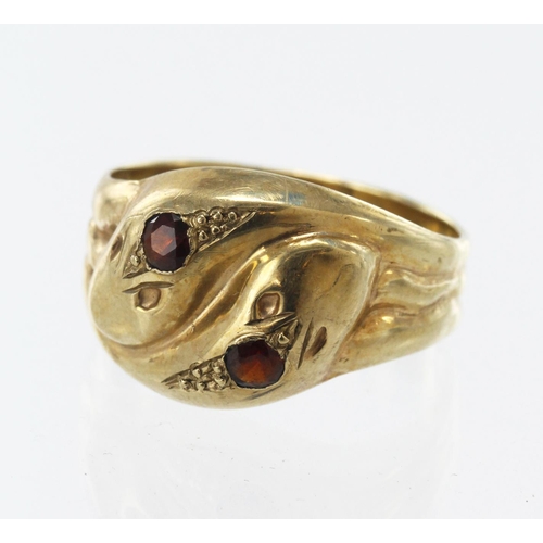 556 - 9ct yellow gold double serpent head ring, set with two approx. 3mm garnets, head width 14mm, finger ... 