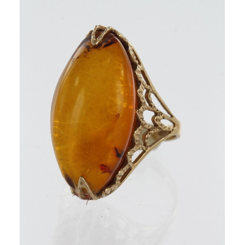 593 - Yellow gold (tests 14ct) amber dress ring, amber measures 25mm x 13mm, finger size N/O, weight 5g.