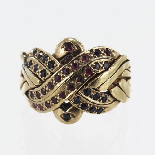 595 - Yellow gold (tests 9ct) eight piece puzzle ring, set with rubies and sapphires, head measures 18mm, ... 