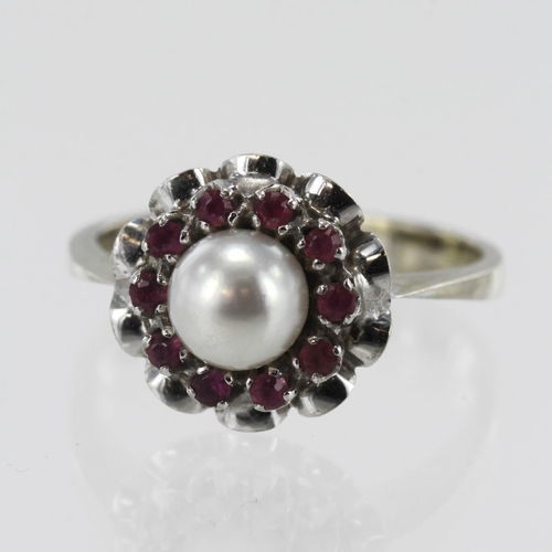 603 - White gold (tests 18ct) pearl and ruby dress ring, one cultured pearl approx. 6mm, surrounded by ten... 