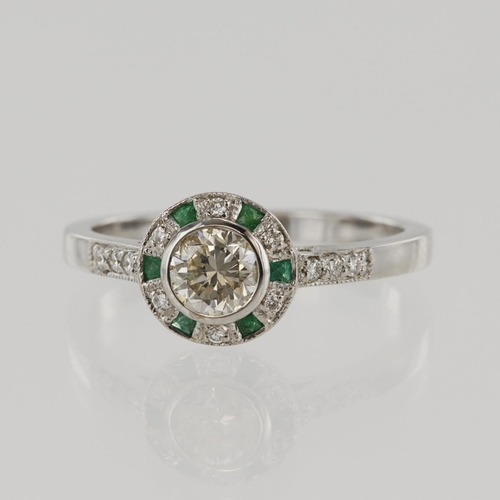 613 - White gold (tests 18ct) diamond and emerald target cluster ring, principle round brilliant cut appro... 