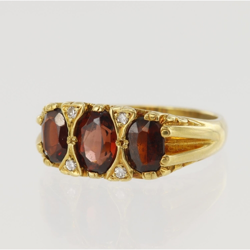 640 - Yellow gold (tests 18ct) diamond and garnet ring, three graduating oval garnets, principle measures ... 