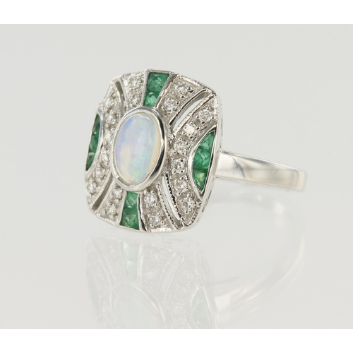 650 - White gold (tests 14ct) diamond, emerald and opal dress ring, opal oval cabochon approx. 0.50ct meas... 