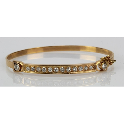 942 - Yellow gold (tests above 18ct) diamond bangle, set with fourteen round brilliant cuts, TDW approx. 0... 