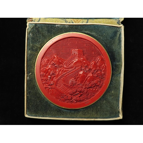 763 - China, antique/vintage red laquer medallion featuring the Great Wall, d.61mm. EF with original case.