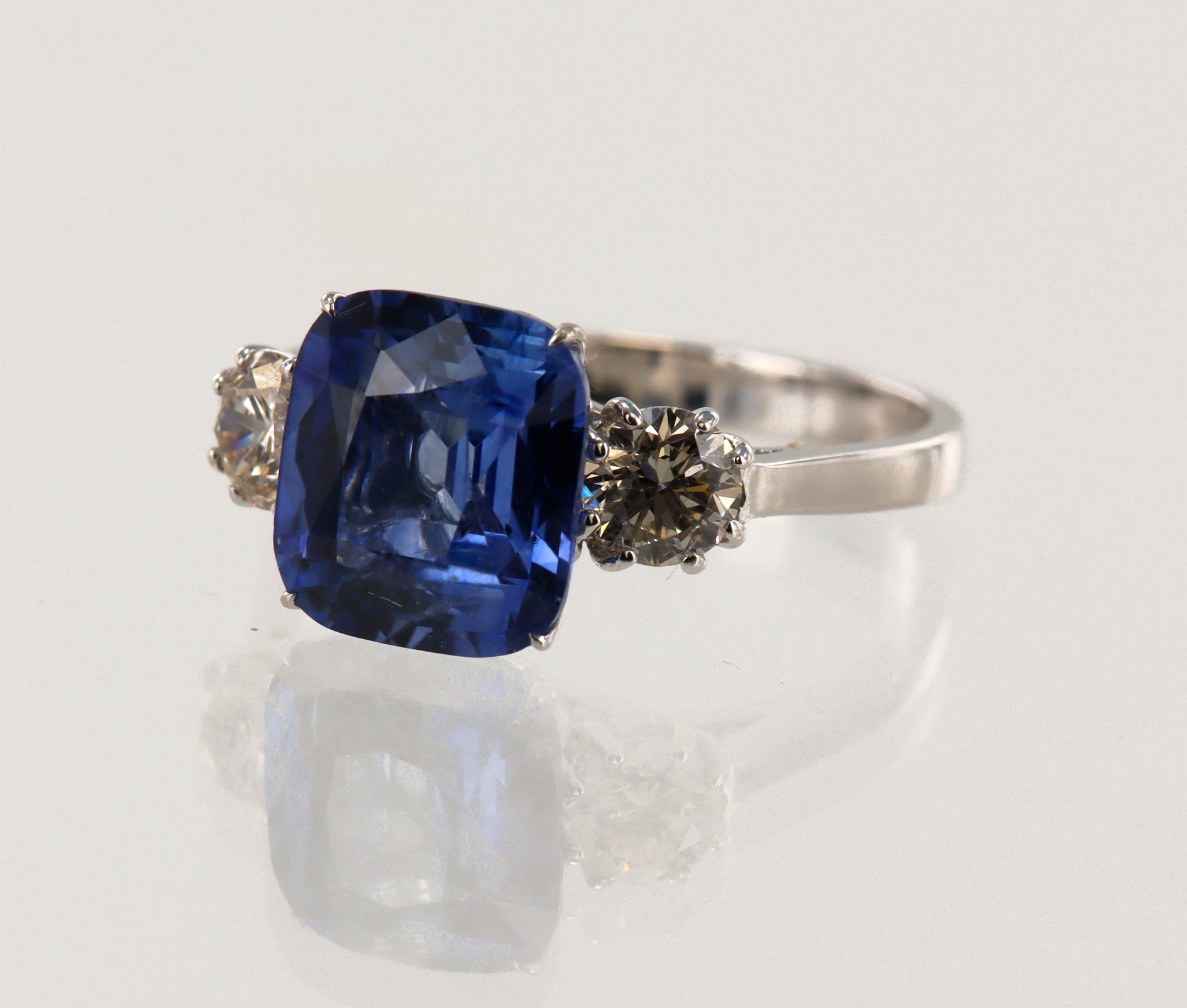 White gold (tests 18ct) diamond and cornflower blue sapphire trilogy ...