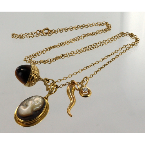 372 - Yellow gold (tests 9ct) chain with four pendants, one tigers eye acorn, black mother of pearl cameo ... 