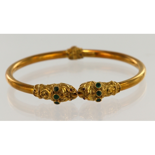 389 - Yellow gold (tests 18ct) double headed dragon bangle, each head set with ruby eyes and three emerald... 