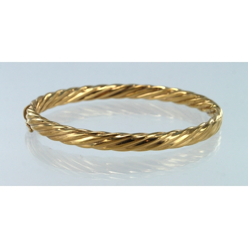 391 - 9ct yellow gold twisted hinged bangle, inside diameter approx. 62mm x 53mm, box clasp fitting, weigh... 