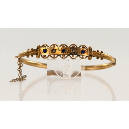 510 - Yellow gold (tests 9ct) antique bangle, set with blue paste and seed pearls, ginged with box clasp, ... 