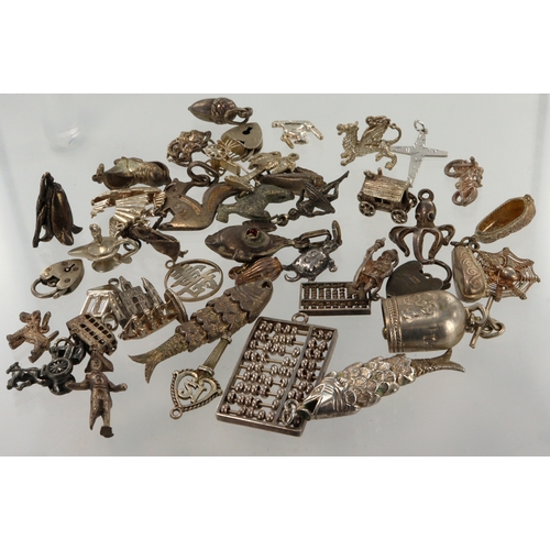 558 - Assortment of silver/white metal charms, total weight 110g.