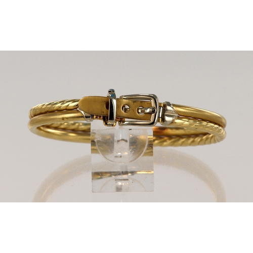 561 - Yellow gold (tests 14ct) hinged buckle bangle, with white gold buckle details, adjustable size insid... 