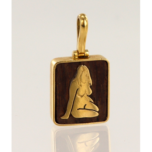 642 - Yellow gold (tests 18ct) mounted wooden pendant, wood measures 16mm x 14mm, with female gold motif o... 