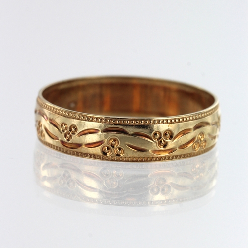 92 - 9ct yellow gold patterned wedding band, width 5mm, finger size T, weight 2.1g.