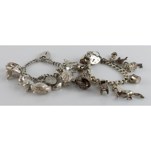 643 - Two silver / white metal charm bracelets with a good variety of charms attached. Total weight 177.4g