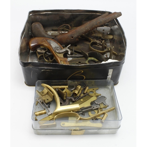 107 - Parts, large tin of antique gun parts, including a lock, hammer and stock of a Philadelphia Derringe... 