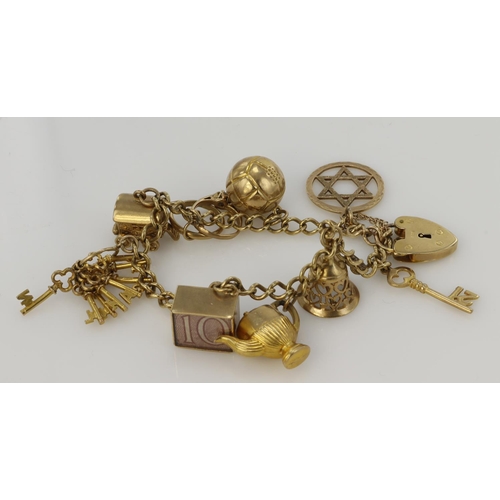 468 - Yellow metal (test 9ct) / 9ct charm bracelet with  variety of charms attached. Total weight 26.9g