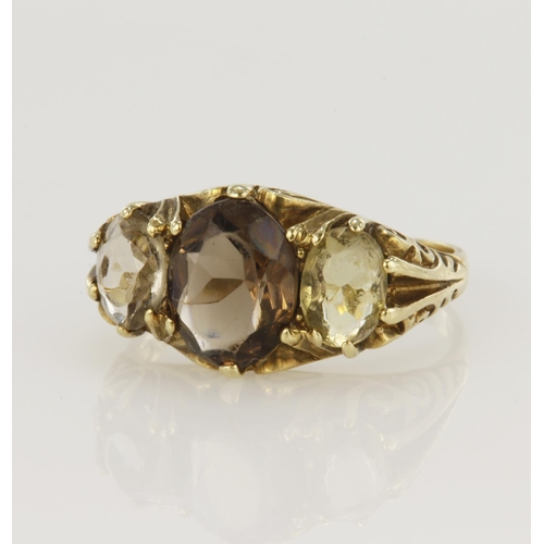 67 - 9ct yellow gold carved head three stone ring set with a central smoky quartz measuring approx. 10mm ... 