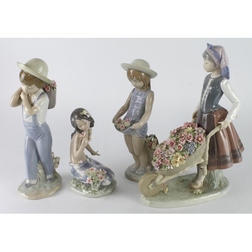 414 - Lladro. Four Lladro figures, comprising a girl pushing a wheel barrow, a Hawaiian girl, and a boy an... 