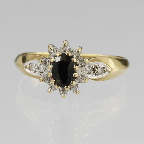 101 - 9ct yellow gold cluster ring set with central oval sapphire measuring approx. 6mm x 4mm surrounded b... 