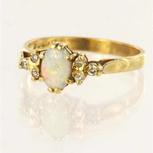 119 - 18ct yellow gold ring set with central oval opal cabochon measuring approx. 7mm x 5mm with three rou... 