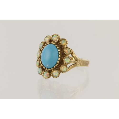 153 - 9ct yellow gold cluster ring set with a central oval turquoise cabochon measuring approx. 9mm x 7mm,... 