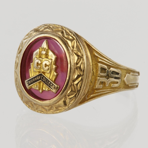 164 - Stamped 10ct college ring set with oval red glass with Chapman College shield, shoulder decorated wi... 