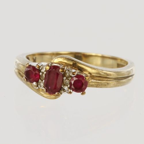 24 - 9ct yellow gold ruby three stone ring with diamond highlights, central oval ruby measuring approx. 5... 