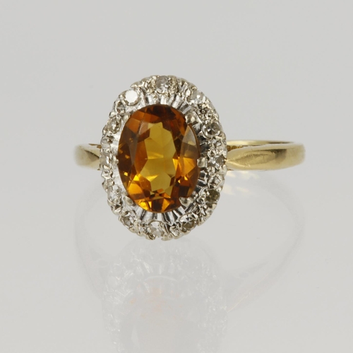 8 - 18ct yellow gold cluster ring set with a central oval topaz measuring approx. 10mm x 6.5mm, surround... 