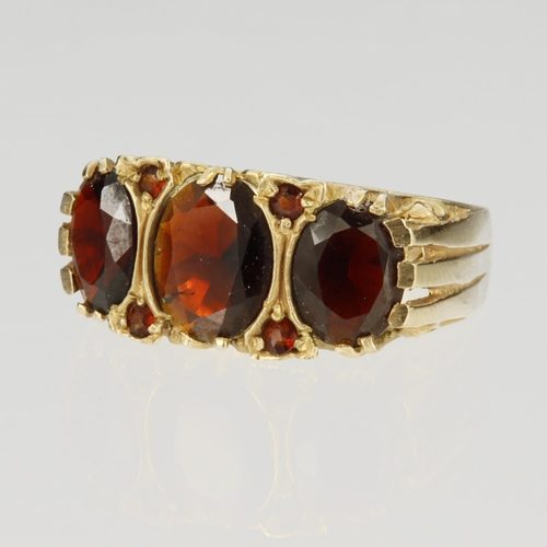 92 - 9ct yellow gold carved head ring set with three principal oval garnets, centre stone measuring appro... 