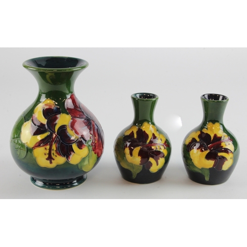 319 - Moorcroft. Three Moorcroft Hibiscus pattern vases, makers marks to base of each, tallest 13cm approx... 